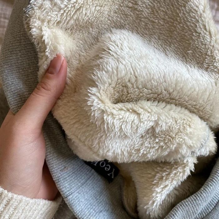 A reviewer is seen holding the pants, showcasing the soft and fluffy interior lining.