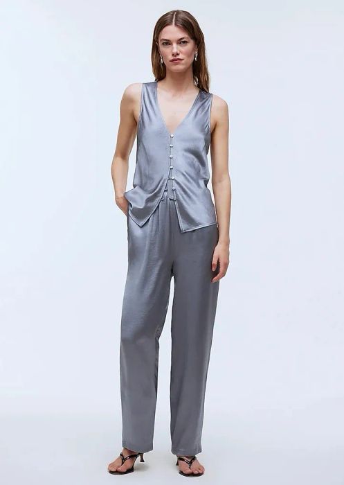 a model dressed in light blue pants paired with a coordinating vest