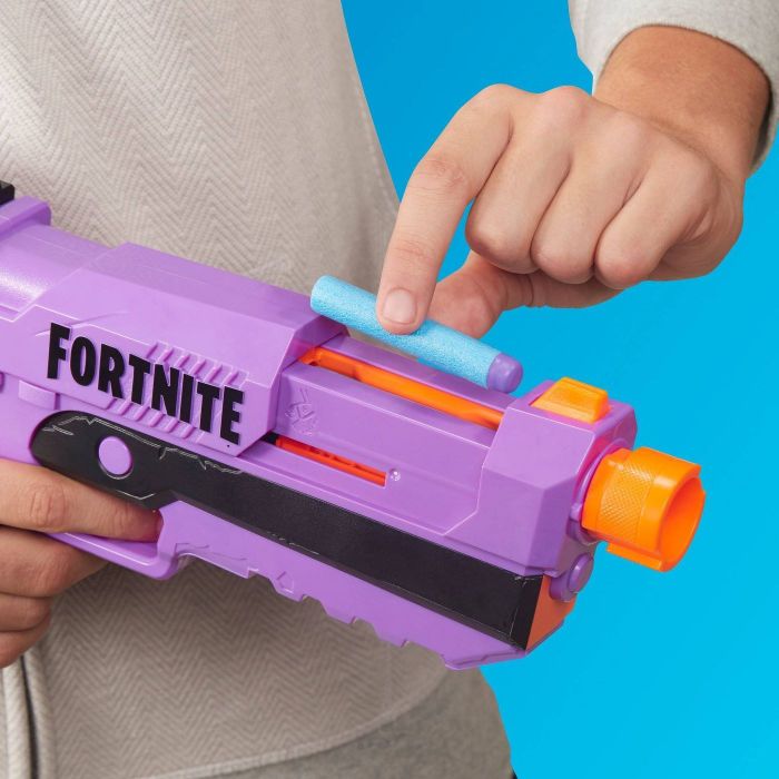 A model loading a foam Nerf dart into the Nerf gun.