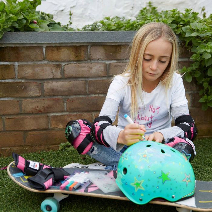 A young girl coloring a teal helmet.