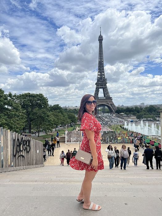A reviewer wearing the dress in red floral.