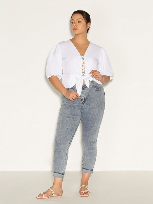model styled in a white bow-tie knotted top