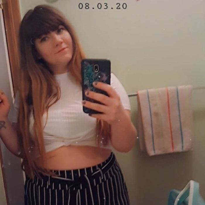 reviewer taking a mirror selfie while wearing the top