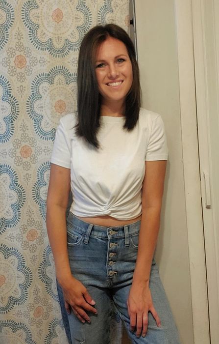reviewer posing in a photo wearing the white twist-front tee paired with jeans