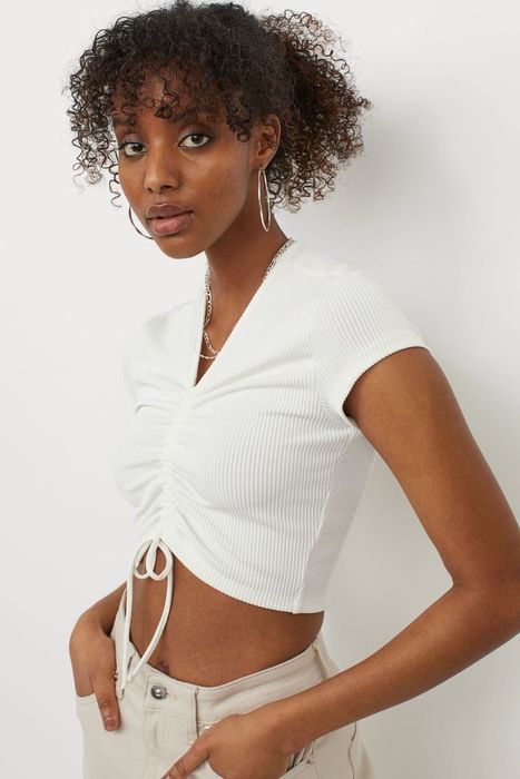 model sporting a white drawstring crop top