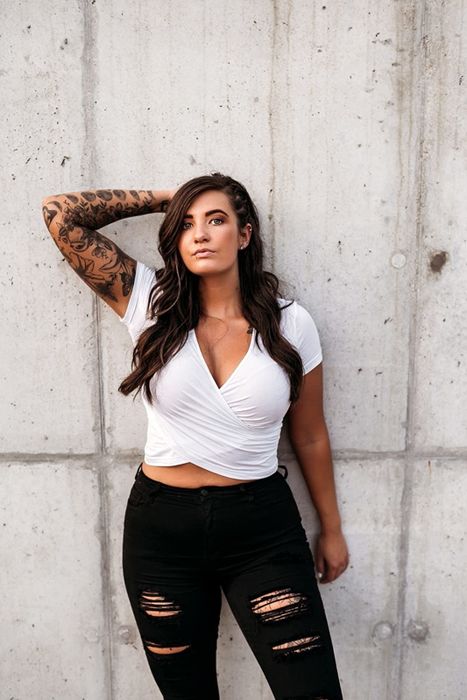 reviewer posing in a white wrap crop top against a wall