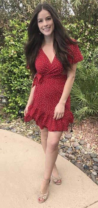 A reviewer wearing the dress in red with nude sandals.