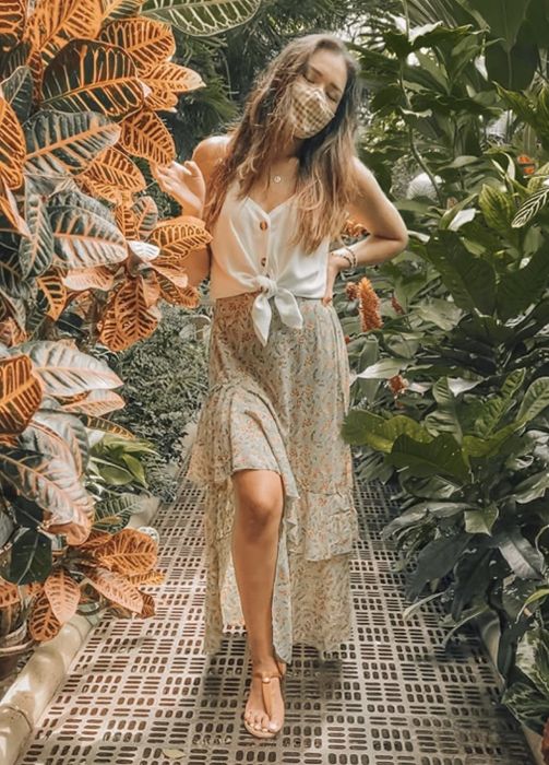 A reviewer wearing the top with the front bottom tied into a knot.