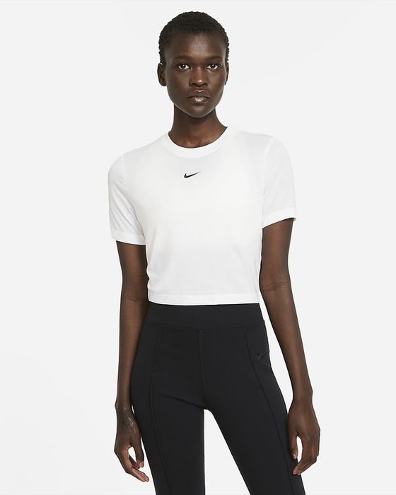 model wearing a Nike crop top paired with black leggings
