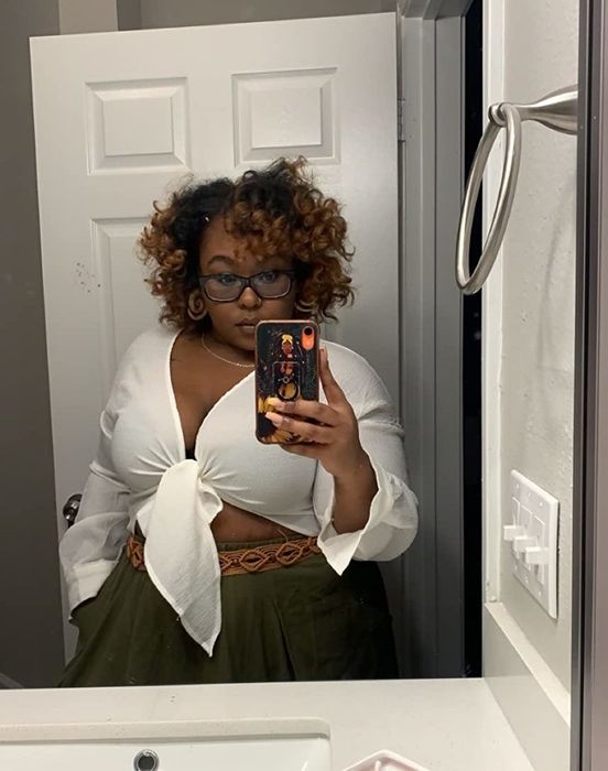 reviewer posing in a mirror selfie wearing a white tie-front blouse