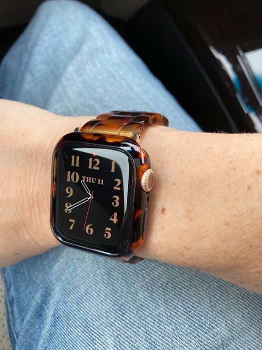 A reviewer wearing a watch with a tortoise shell band.