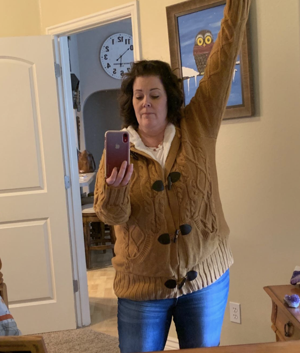 A customer review photo of them posing in the sweater, capturing the moment in a mirror selfie.