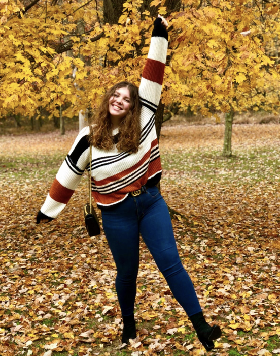 A customer photo of them wearing the sweater with bold black and brown stripes.