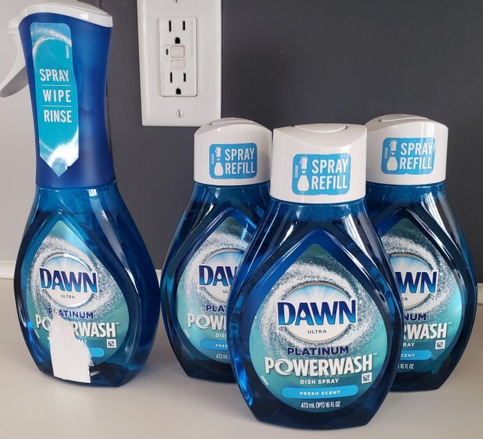 A reviewer's Dawn Powerwash spray along with three refills.
