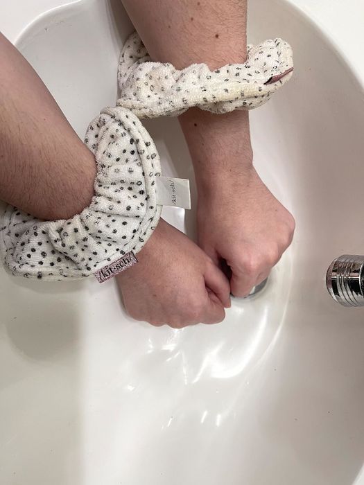 The reviewer demonstrates the absorbency of the scrunchies.