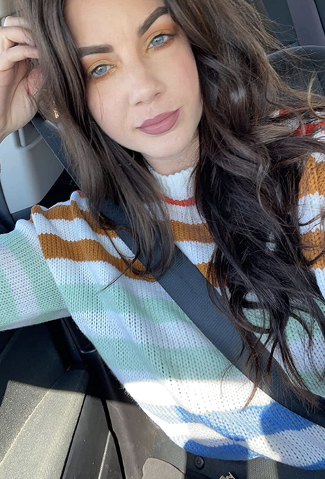 A customer photo of them enjoying the sweater while sitting in their car, ready for an adventure.
