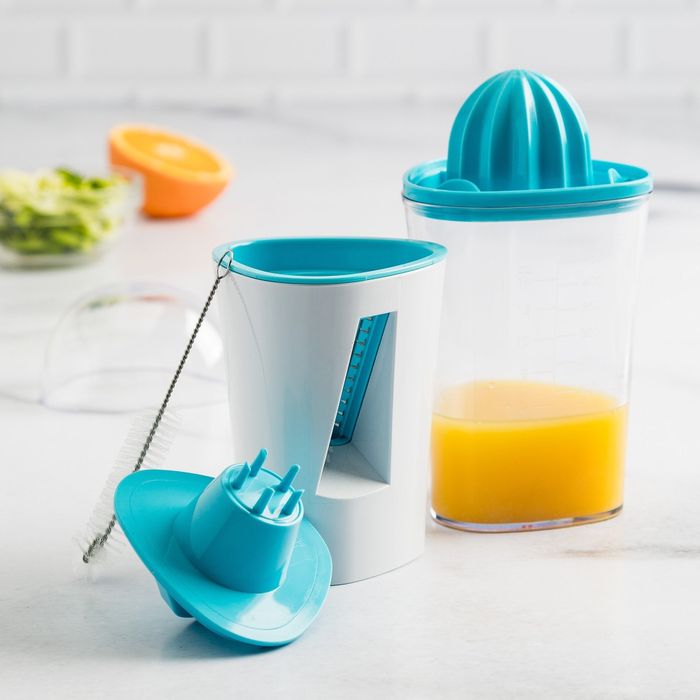 Juicer and spiralizer with fresh fruit juice in container