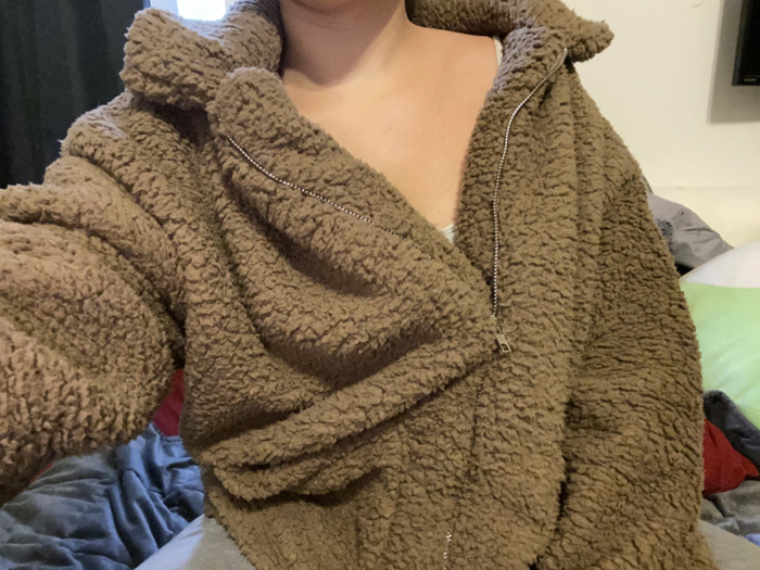 A close-up customer photo of them wearing the jacket in a rich brown hue.