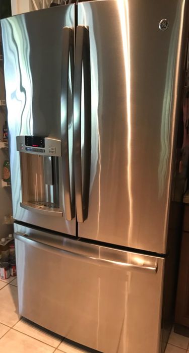 The same stainless steel refrigerator after it has been thoroughly cleaned, now looking shiny and spotless.