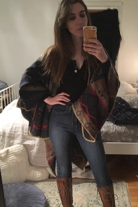 A customer review showing them taking a mirror selfie while wearing a cozy poncho