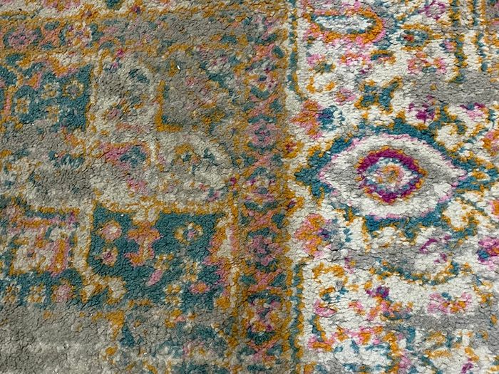A carpet with one half visibly dirty and the other half spotless.