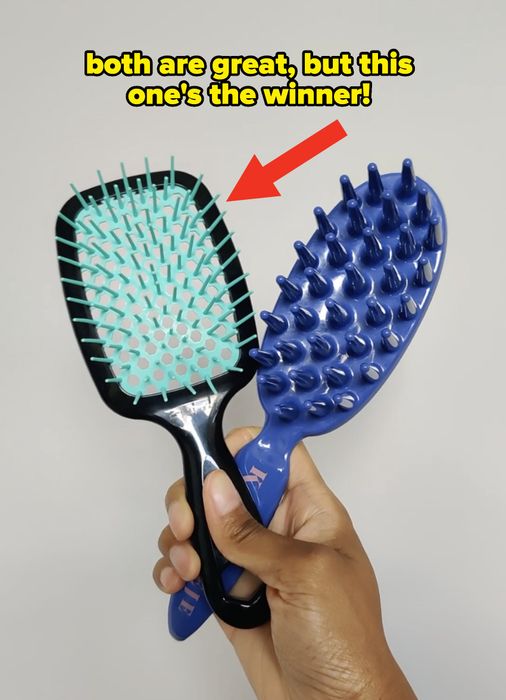 A hand holding two hairbrushes, each featuring a different bristle design.