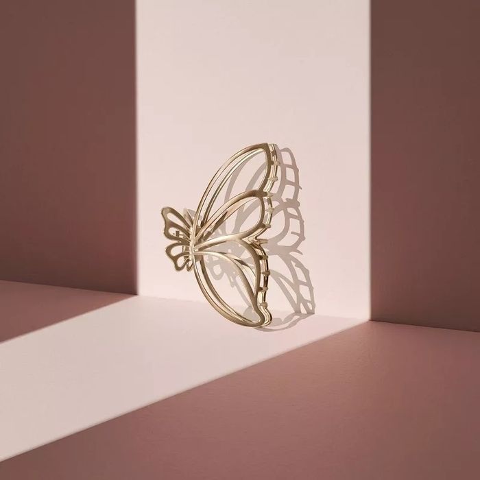 A metallic butterfly decorative piece casting intricate shadows on angled surfaces.