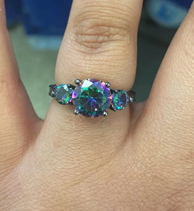 A reviewer photo of the topaz ring featuring a mesmerizing mix of green, purple, pink, and blue hues in all three stones.