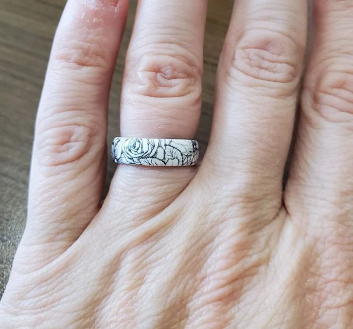 A photo of the reviewer wearing the white silicone band, featuring a black rose line drawing.