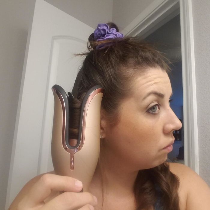 The same reviewer with their hair secured in the curling tool
