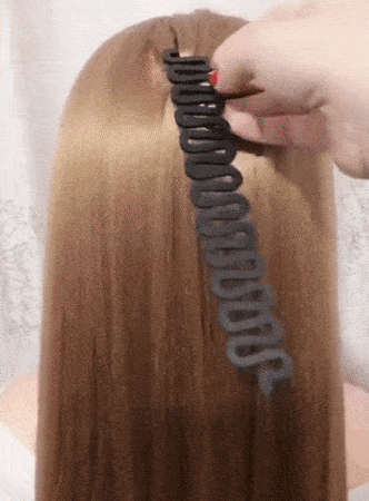 A gif demonstrating a model's hair being braided effortlessly with the braiding tool