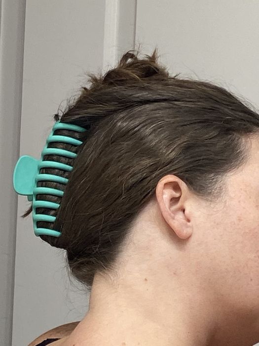 A teak clip securing the reviewer's hair in place.