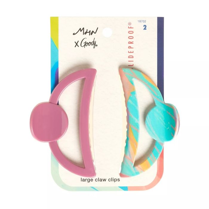Two oversized claw clips by Mow x Goody. One is a solid pink, while the other has a swirl pattern in multicolors. The text reads: 'SlideProof.'