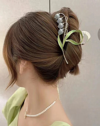 a model showcasing a lily-themed claw clip in their hair
