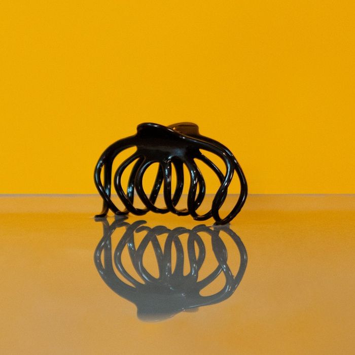 Product image of the clip standing upright against a bright yellow background.