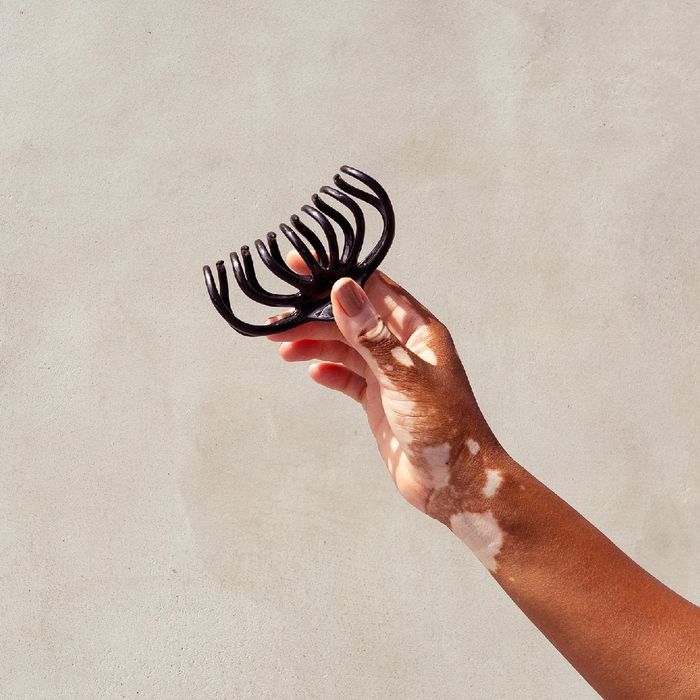 A model's hand holding the stylish claw clip.