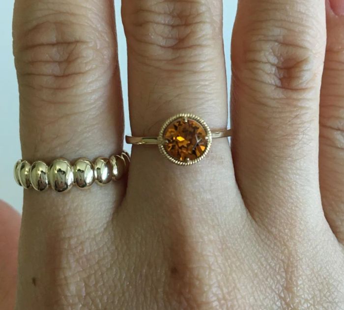 Customer photo showcasing a ring with a gold band and a round orange stone