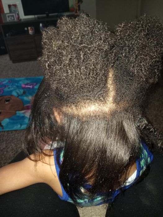 a person displaying a split hairstyle—half natural and half straightened