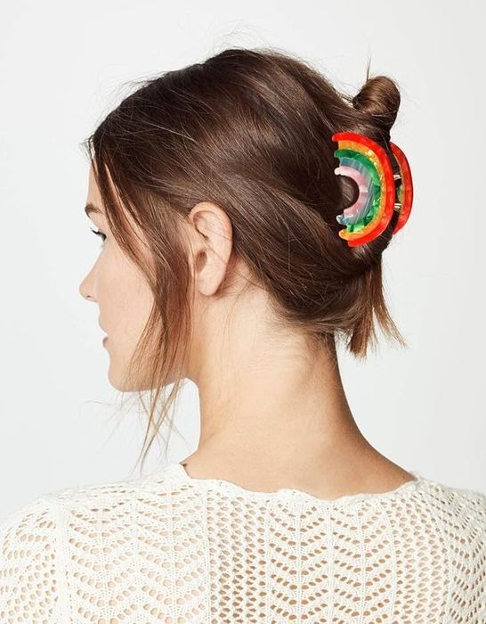 A woman with a unique circular rainbow hair accessory in her bun, viewed from behind.