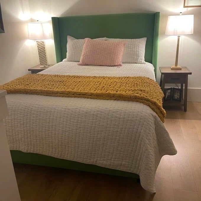 A vibrant yellow chunky blanket elegantly draped over a bed, adding a pop of color and warmth to the room.