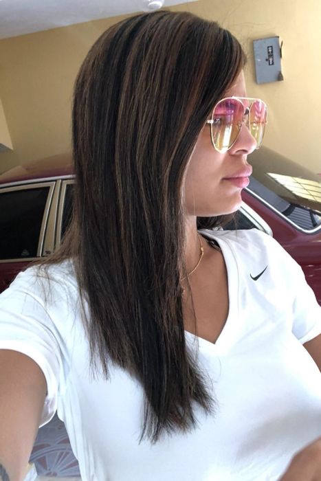 A reviewer showcases their straightened hair after using a leave-in treatment.