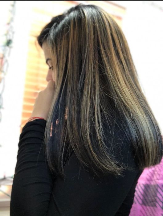 A reviewer with longer, color-treated hair displays a silky, smooth finish after using the product.