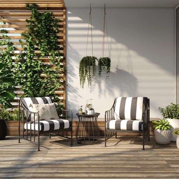 A black bistro set featuring a small table and two chairs, each with black and white striped cushions.