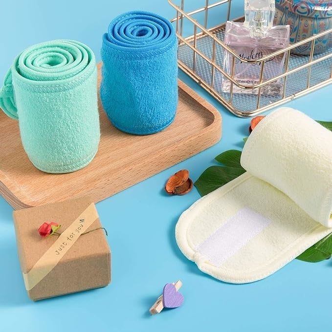 Three spa headbands in various colors arranged on a blue table