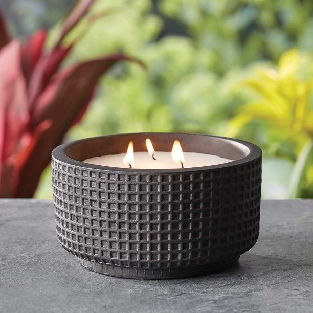 A black ceramic citronella candle with three wicks.