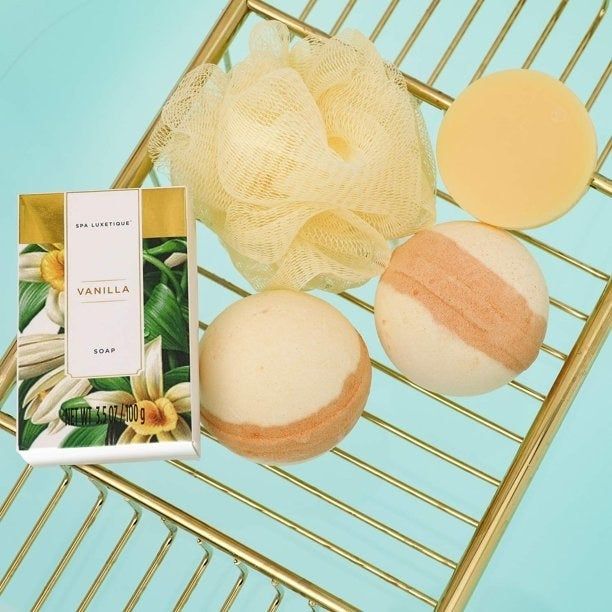 Soap, bath bombs, and a loofah from the luxurious spa gift set, ready for a relaxing experience.