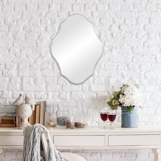 the frameless mirror displayed on a wall