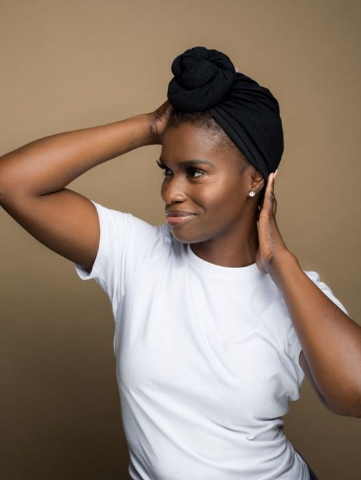 A model showcasing a black T-shirt with a bun wrap.