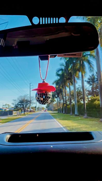 The cowgirl disco ball hanging from the rearview mirror of a car