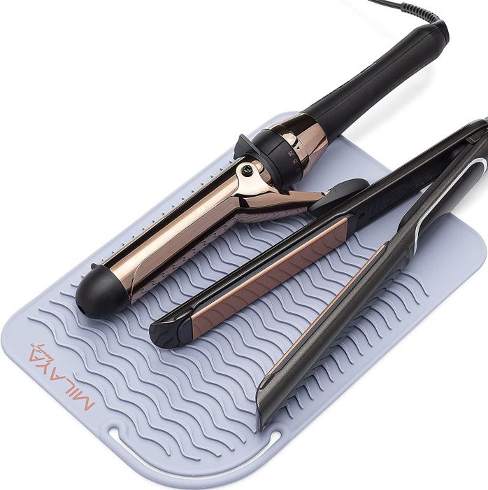 A lavender silicone mat with two hot styling tools resting on it